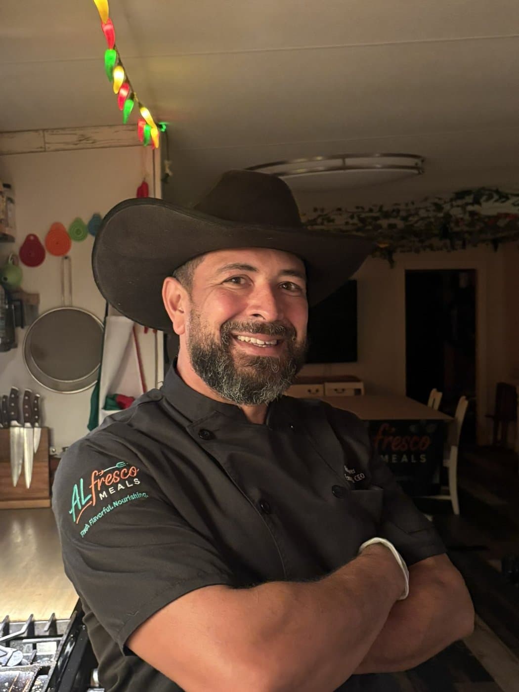 Chef Al in his kitchen, arms crossed, wearing his Alfresco Meals chef coat
